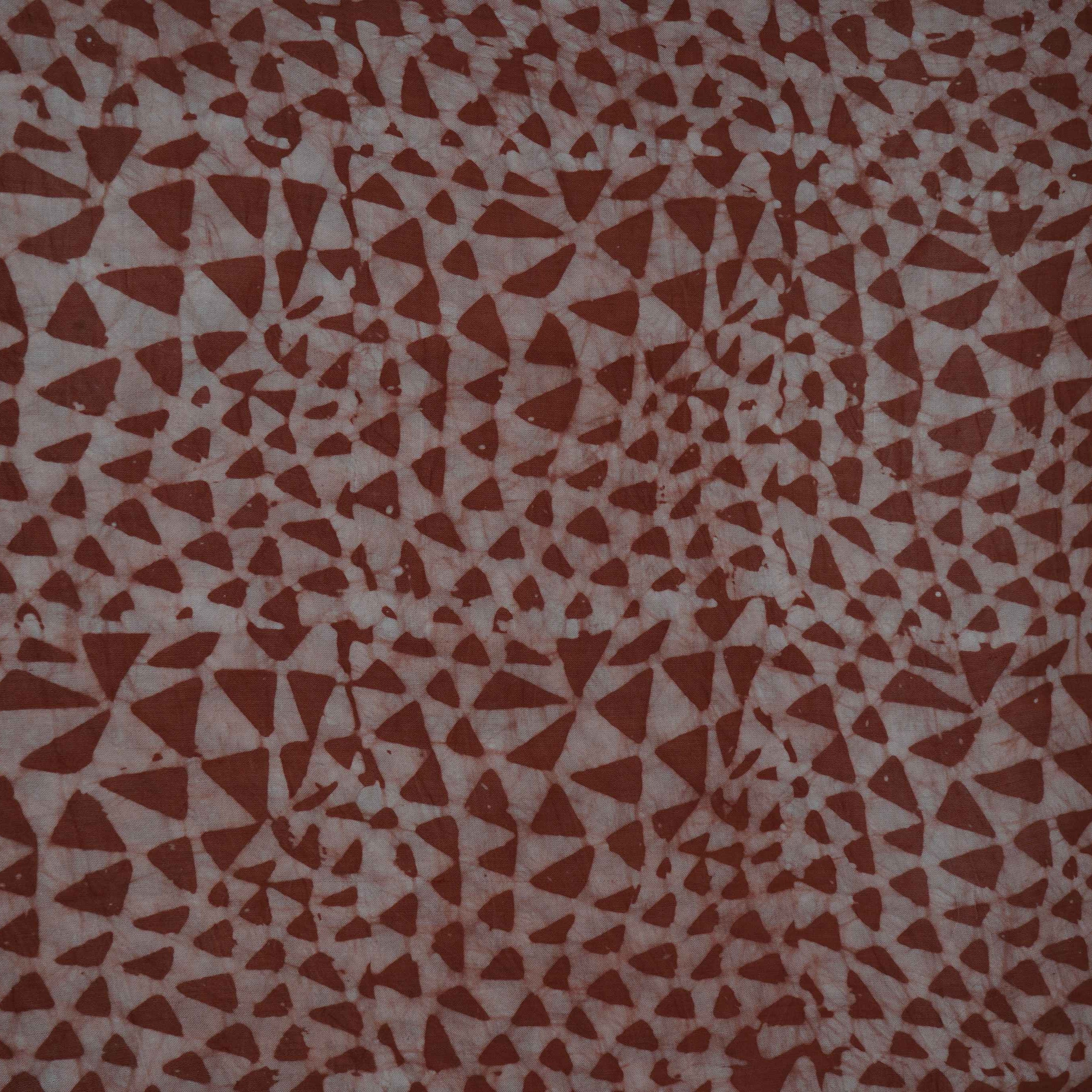 Rust brown geometric batik print light modal satin fabric with a smooth, lustrous sheen, ideal for ethnic wear.