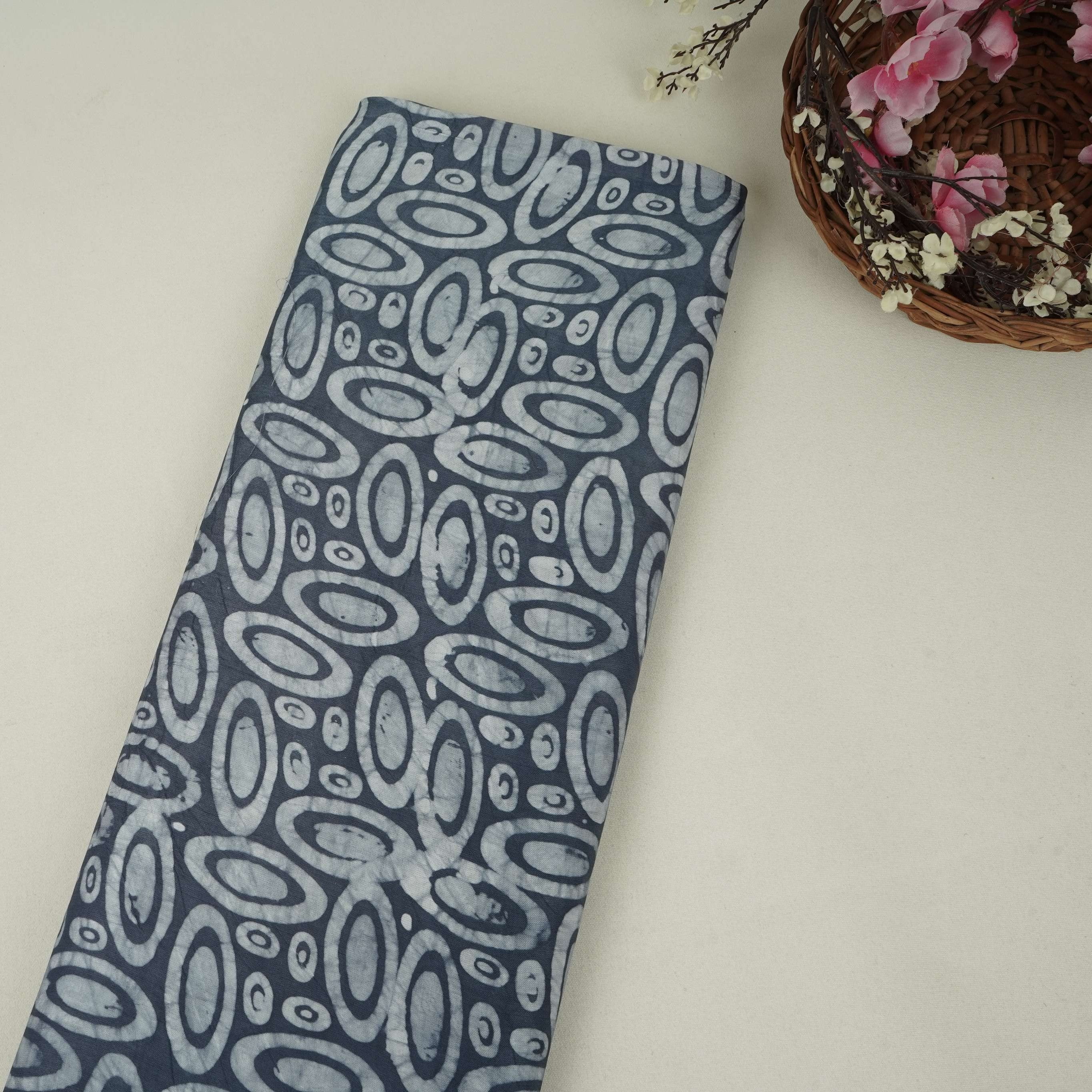 Indigo circle batik print light modal satin fabric with a smooth, lustrous sheen, ideal for ethnic wear.