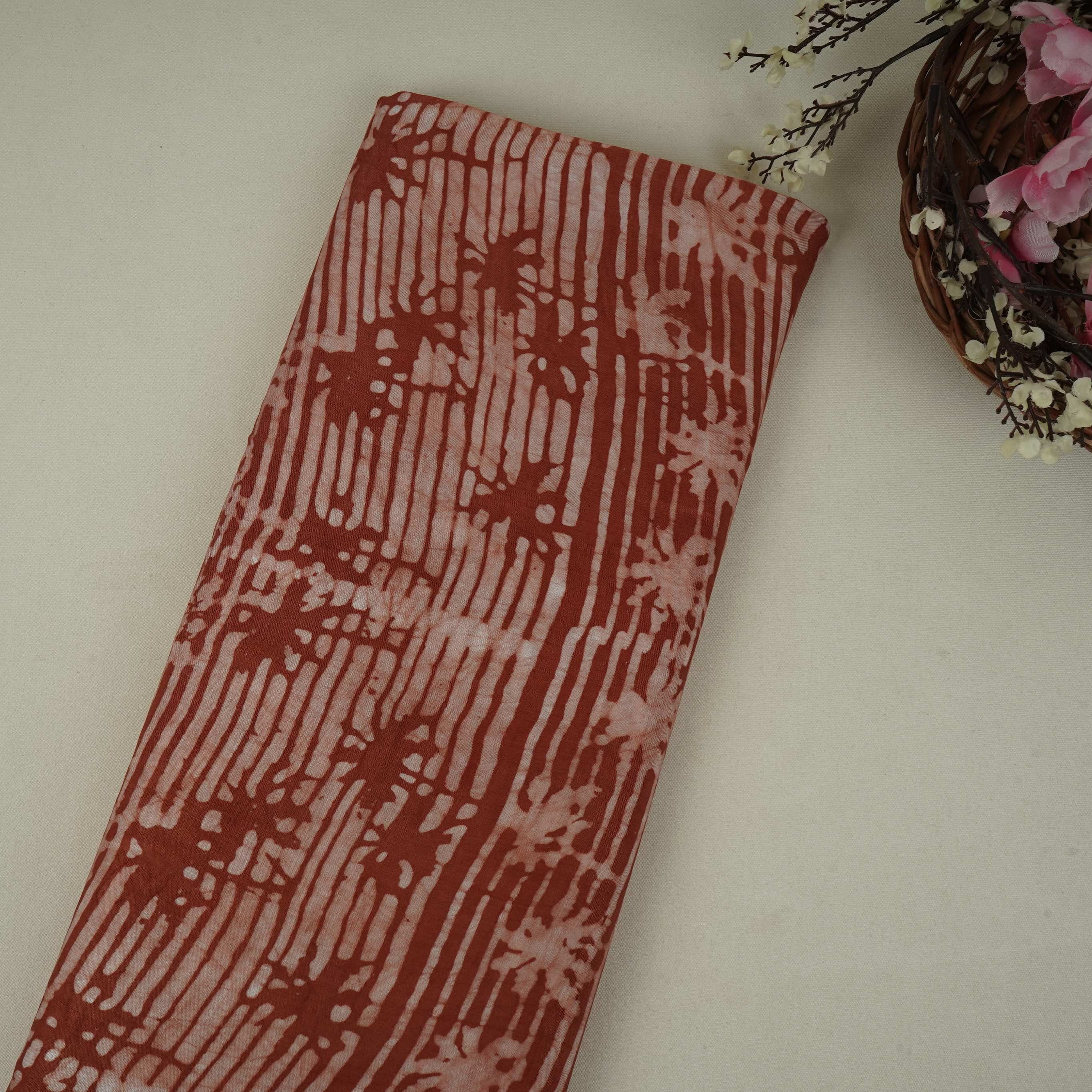 Rust brown abstract batik print light modal satin fabric with a smooth, lustrous sheen, ideal for ethnic wear.