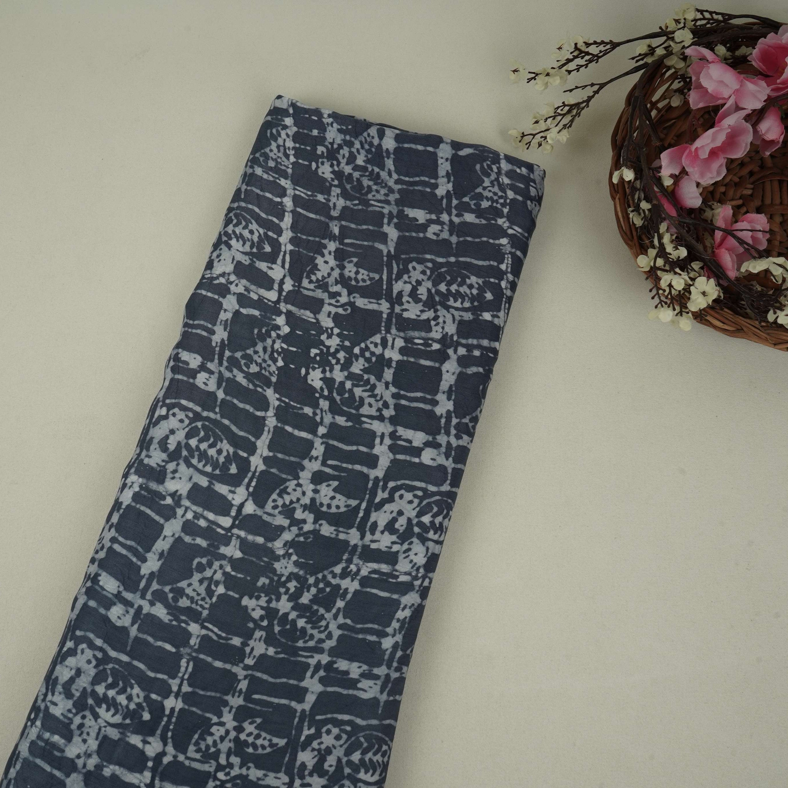 Indigo blue batik print light modal satin fabric with a smooth, lustrous sheen, ideal for ethnic wear.