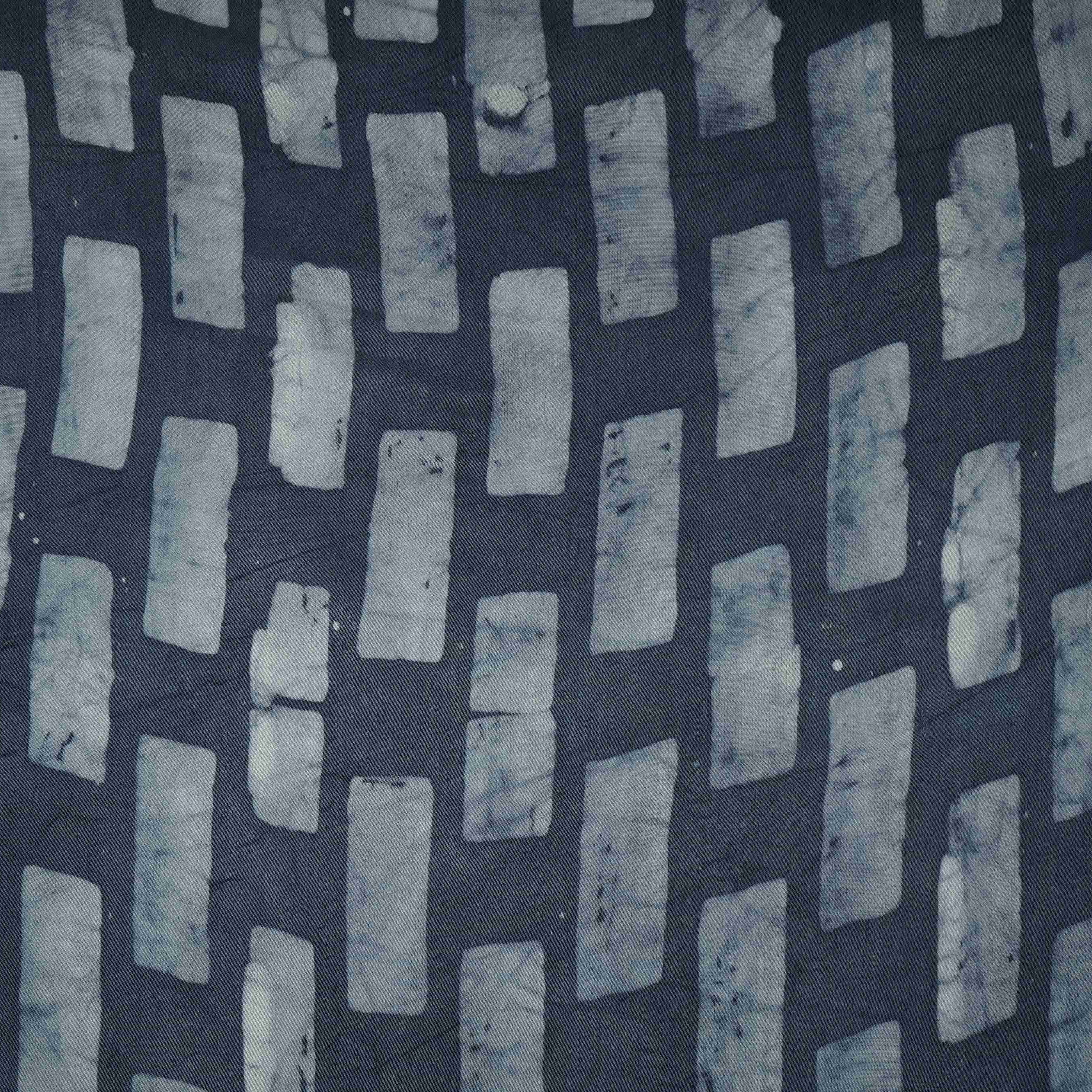 Indigo blue block batik print light modal satin fabric with a smooth, lustrous sheen, ideal for ethnic wear.