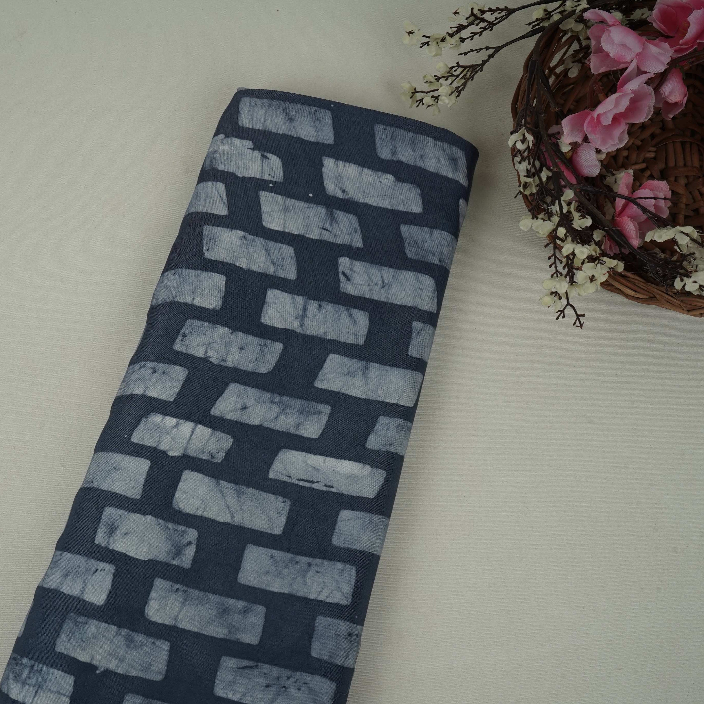 Indigo blue block batik print light modal satin fabric with a smooth, lustrous sheen, ideal for ethnic wear.