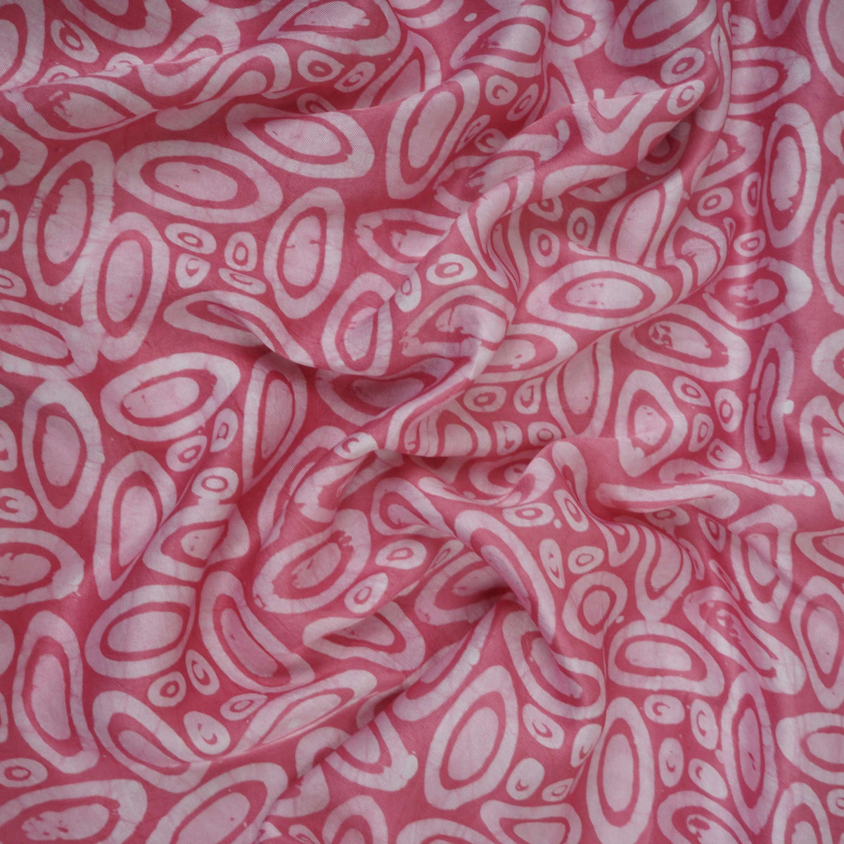 Pink circle batik print light modal satin fabric with a smooth, lustrous sheen, ideal for ethnic wear.