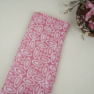 Pink circle batik print light modal satin fabric with a smooth, lustrous sheen, ideal for ethnic wear.